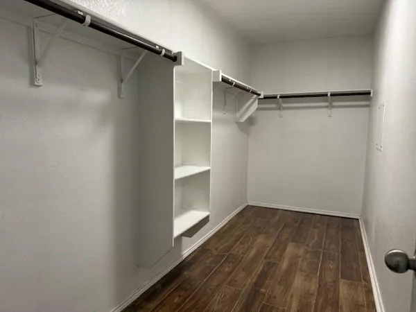 a view of walk in closet with empty racks