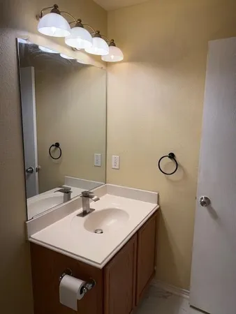 a bathroom with a sink a light fixture and a mirror