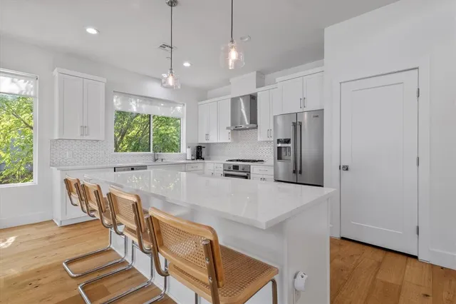 a kitchen with stainless steel appliances granite countertop a refrigerator sink and stove