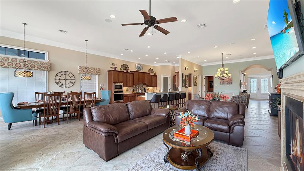 451 Muirfield Loop Reunion, FL 34747 - Photo 17 of 67 a living room with furniture kitchen view and a chandelier