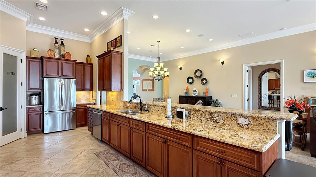 451 Muirfield Loop Reunion, FL 34747 - Photo 20 of 67 a large kitchen with stainless steel appliances granite countertop a refrigerator and a sink