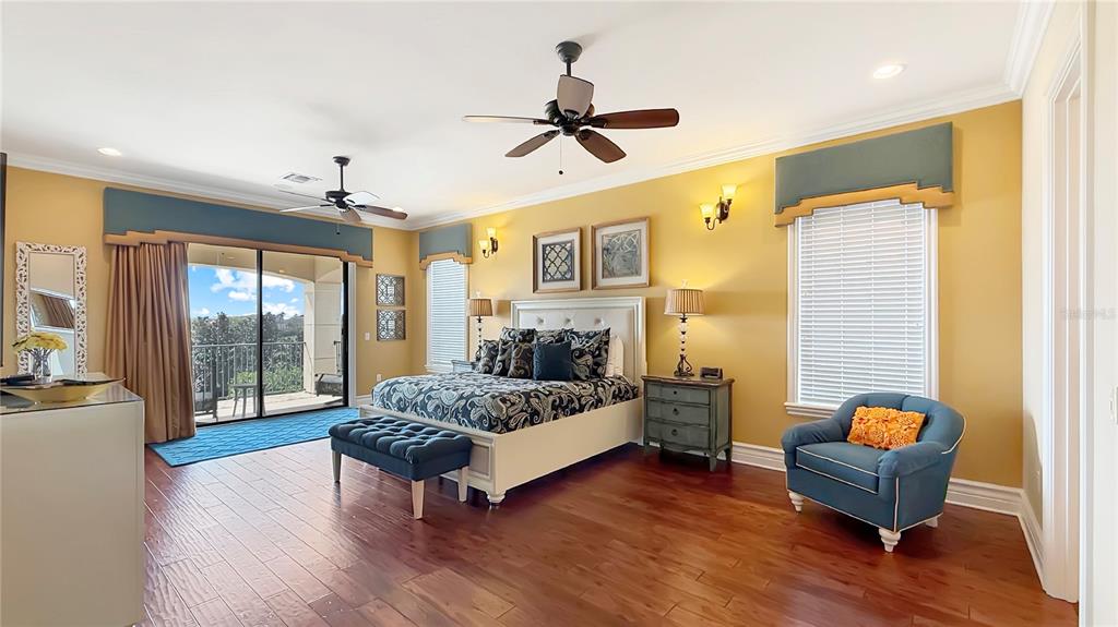 451 Muirfield Loop Reunion, FL 34747 - Photo 38 of 67 a spacious bedroom with a bed and wooden floor