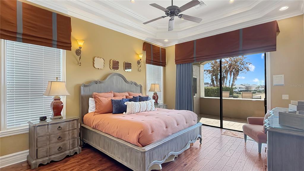 451 Muirfield Loop Reunion, FL 34747 - Photo 49 of 67 a bedroom with a large bed and a chandelier