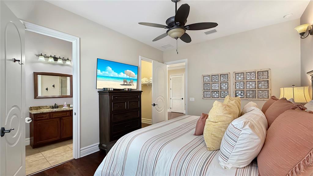 451 Muirfield Loop Reunion, FL 34747 - Photo 50 of 67 a bedroom with a bed and a flat screen tv