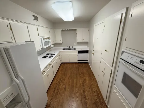 a kitchen with white cabinets and white appliances