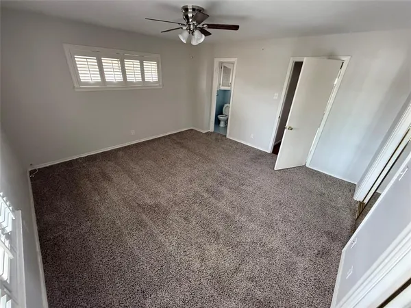 a view of a livingroom with a ceiling fan and window