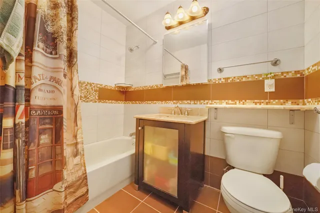 a white toilet sitting next to a bathroom sink and a shower