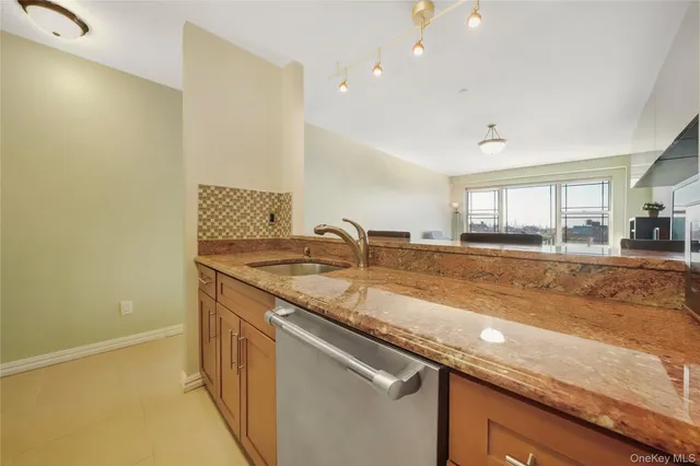 a kitchen with granite countertop a sink and a white cabinets