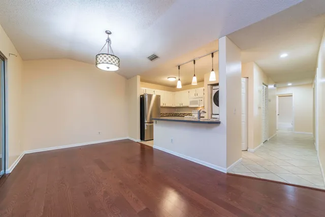 wooden floor in an empty room with a kitchen