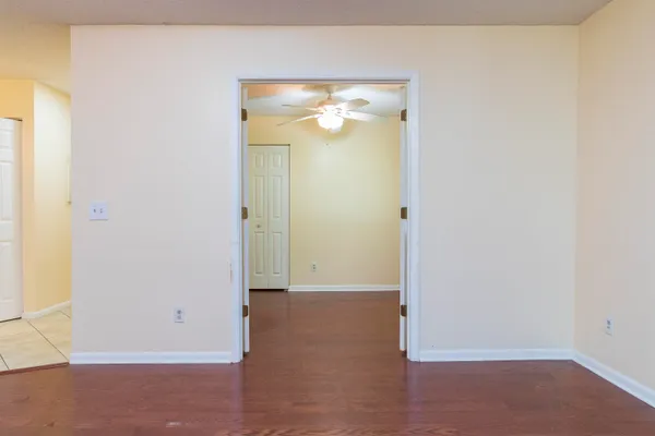 an empty room with closet and a chandelier fan