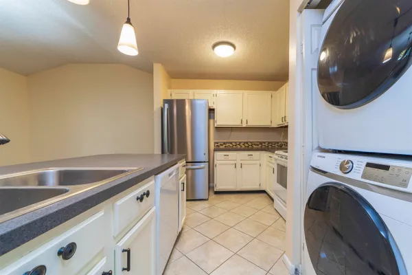 a kitchen with stainless steel appliances granite countertop a sink a stove and a window