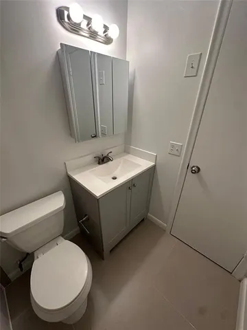 a bathroom with a toilet sink and mirror