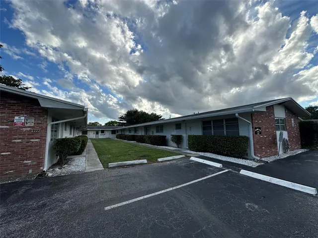 a view of a grey house with a street