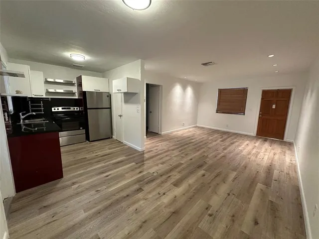 a view of empty room with wooden floor