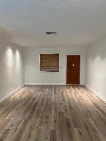 a view of an empty room and wooden floor