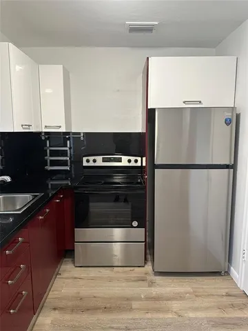 a kitchen with granite countertop a refrigerator and a stove