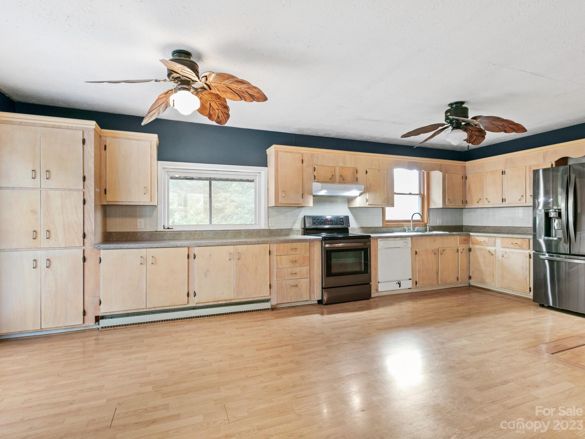 98 Pinecrest Drive Alexander, NC 28701 - Photo 7 of 32 a kitchen with stainless steel appliances a stove a sink and white cabinets