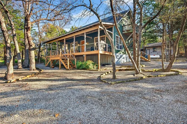 a view of a house with a yard and large trees