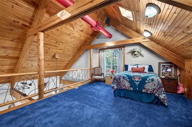 a view of an empty room with wooden floor and furniture