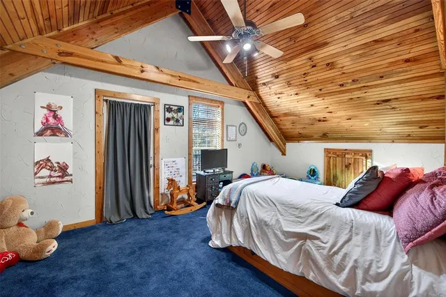 a bedroom with a bed a dresser and paintings on the wall