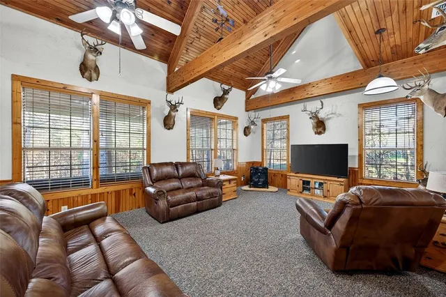 a living room with furniture a flat screen tv and a large window