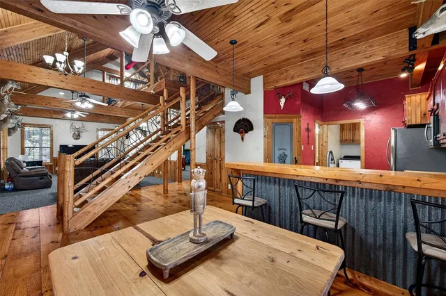 a room with stainless steel appliances kitchen island granite countertop furniture a refrigerator and wooden cabinets