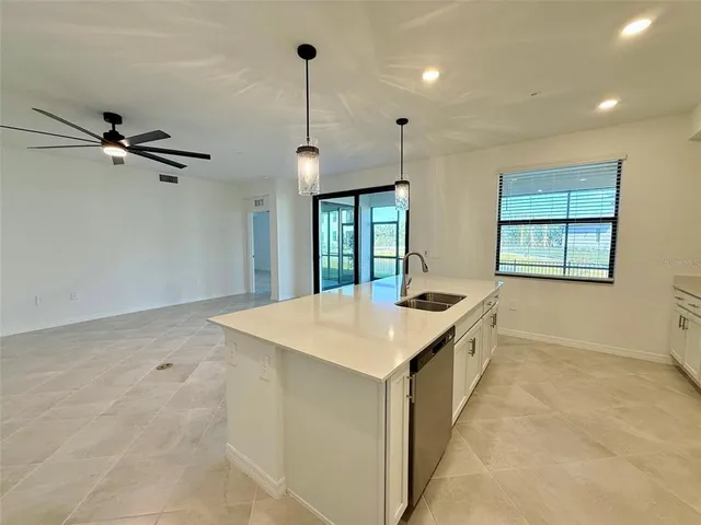 a room with a chandelier a sink a window and a ceiling fan