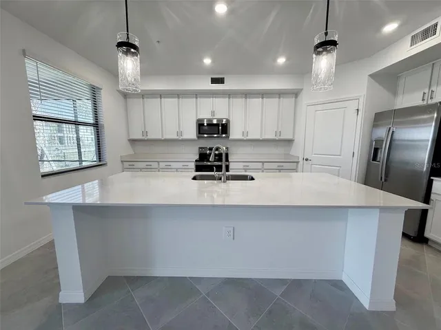 a kitchen with kitchen island a sink stainless steel appliances and window