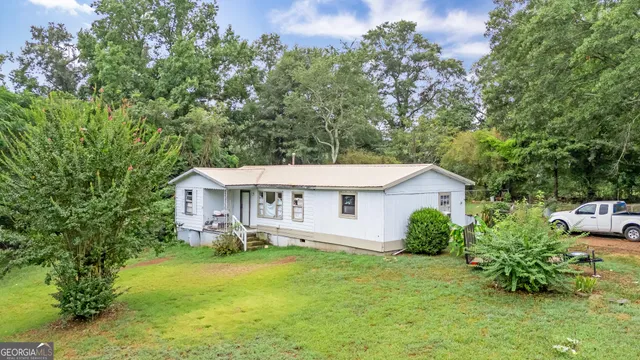 a view of a house with a yard and sitting area
