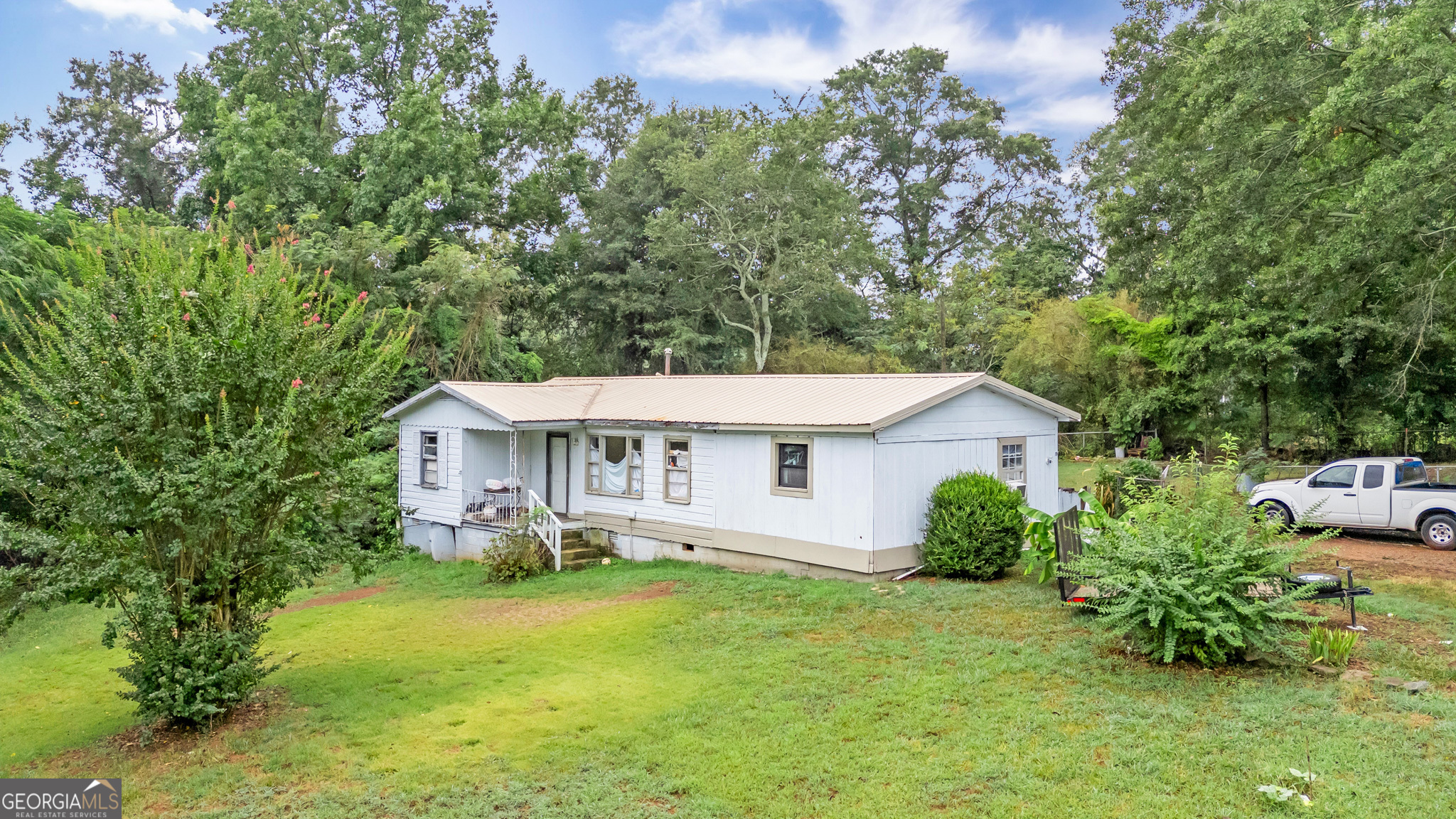 a view of a house with a yard and sitting area