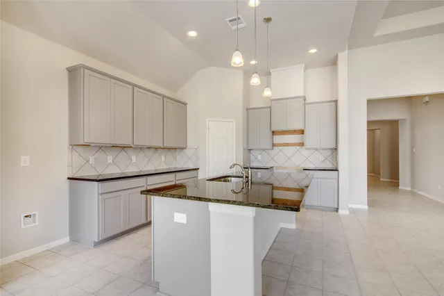 a kitchen with a sink and white cabinets