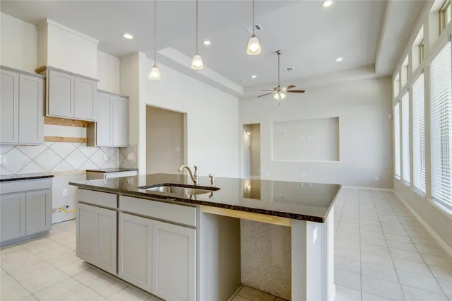 a kitchen with stainless steel appliances granite countertop a sink and a stove top oven with wooden floor
