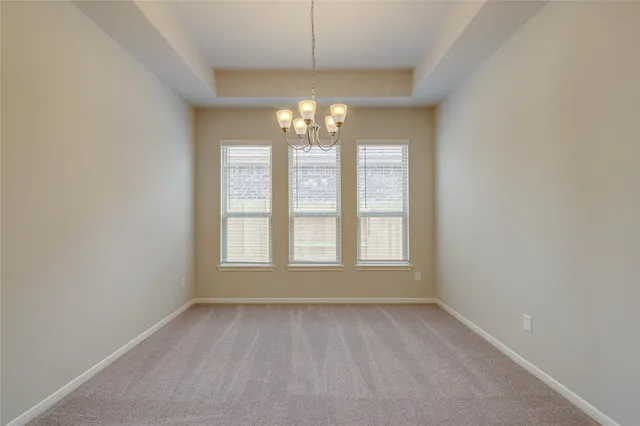 a view of an empty room and kitchen view