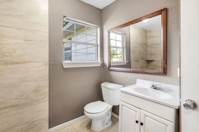 a bathroom with a toilet sink and a mirror