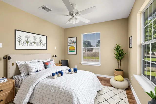 a bedroom with a bed and a large window