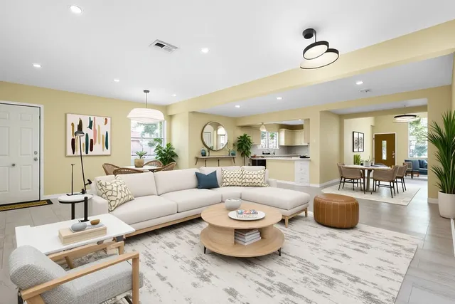 a living room with furniture a rug and a view of kitchen