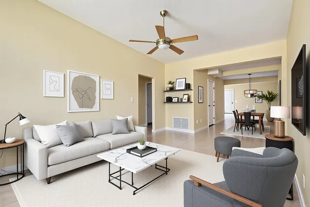 a living room with furniture and a view of kitchen