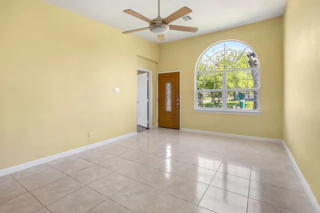 an empty room with windows and fan