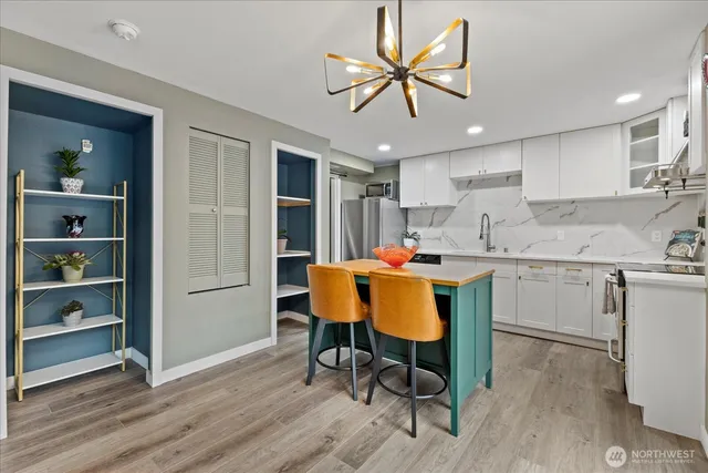 a kitchen with a table chairs refrigerator and microwave