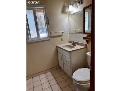 a bathroom with a granite countertop toilet sink and mirror