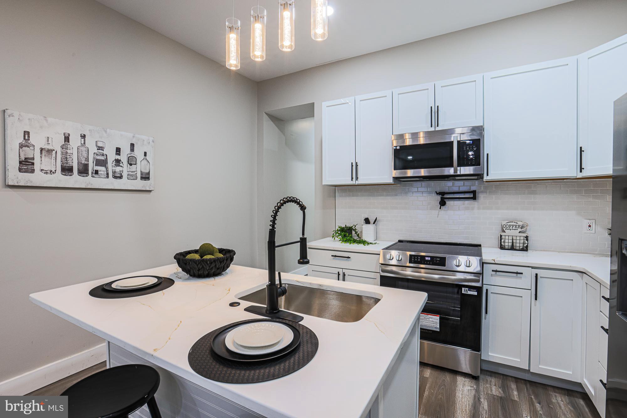 1728 Ruxton Avenue Baltimore, MD 21216 - Photo 11 of 43 a kitchen with a sink a stove and white cabinets