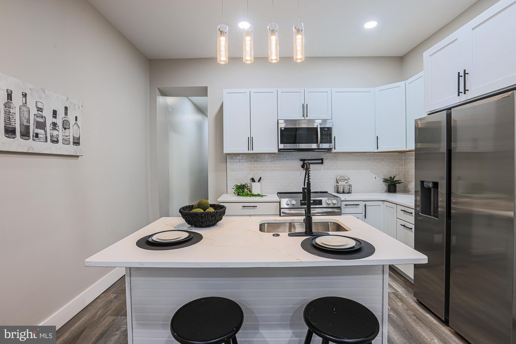 1728 Ruxton Avenue Baltimore, MD 21216 - Photo 13 of 43 a kitchen with a sink a stove a refrigerator and cabinets