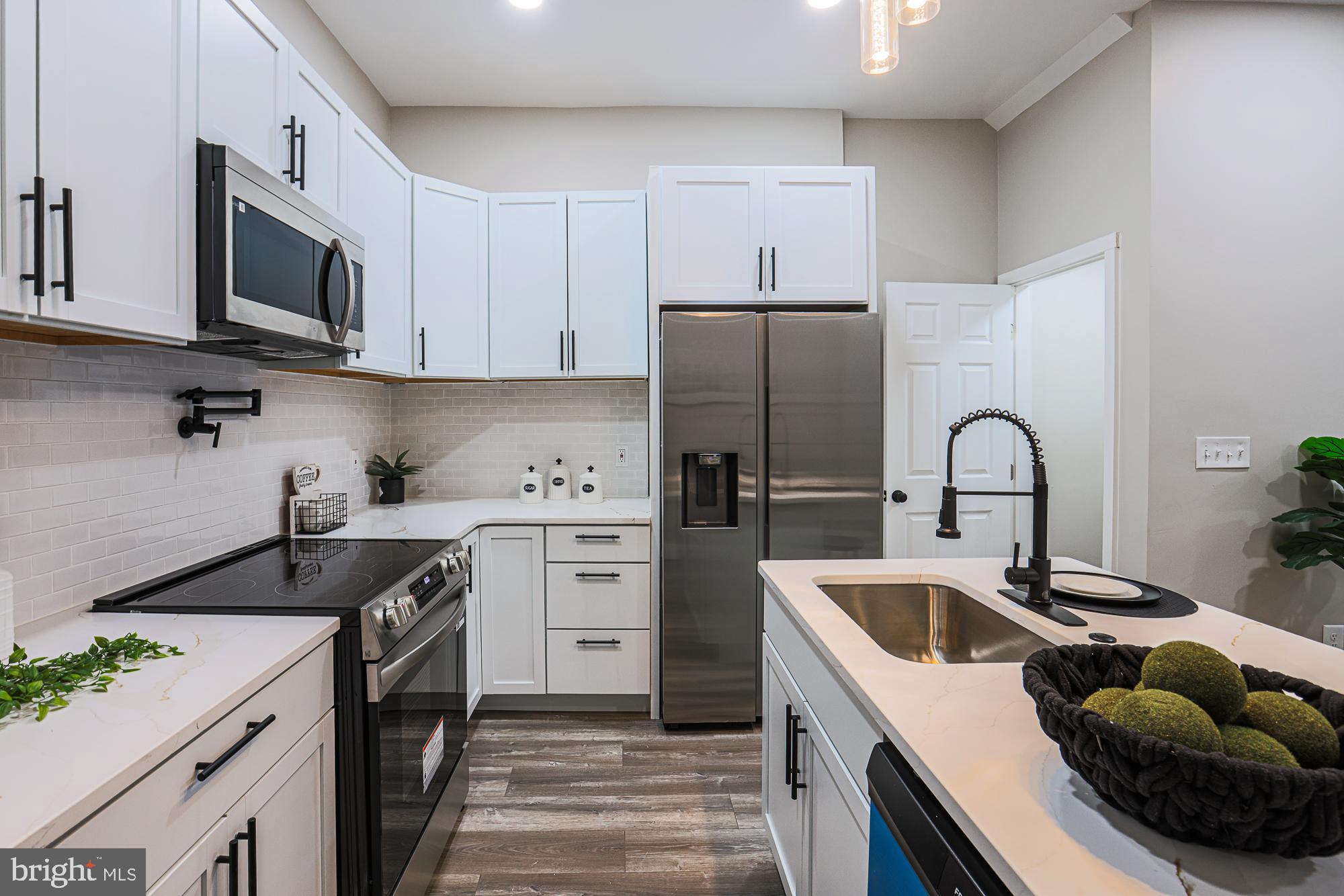 1728 Ruxton Avenue Baltimore, MD 21216 - Photo 15 of 43 a kitchen with stainless steel appliances granite countertop a sink a stove and a refrigerator