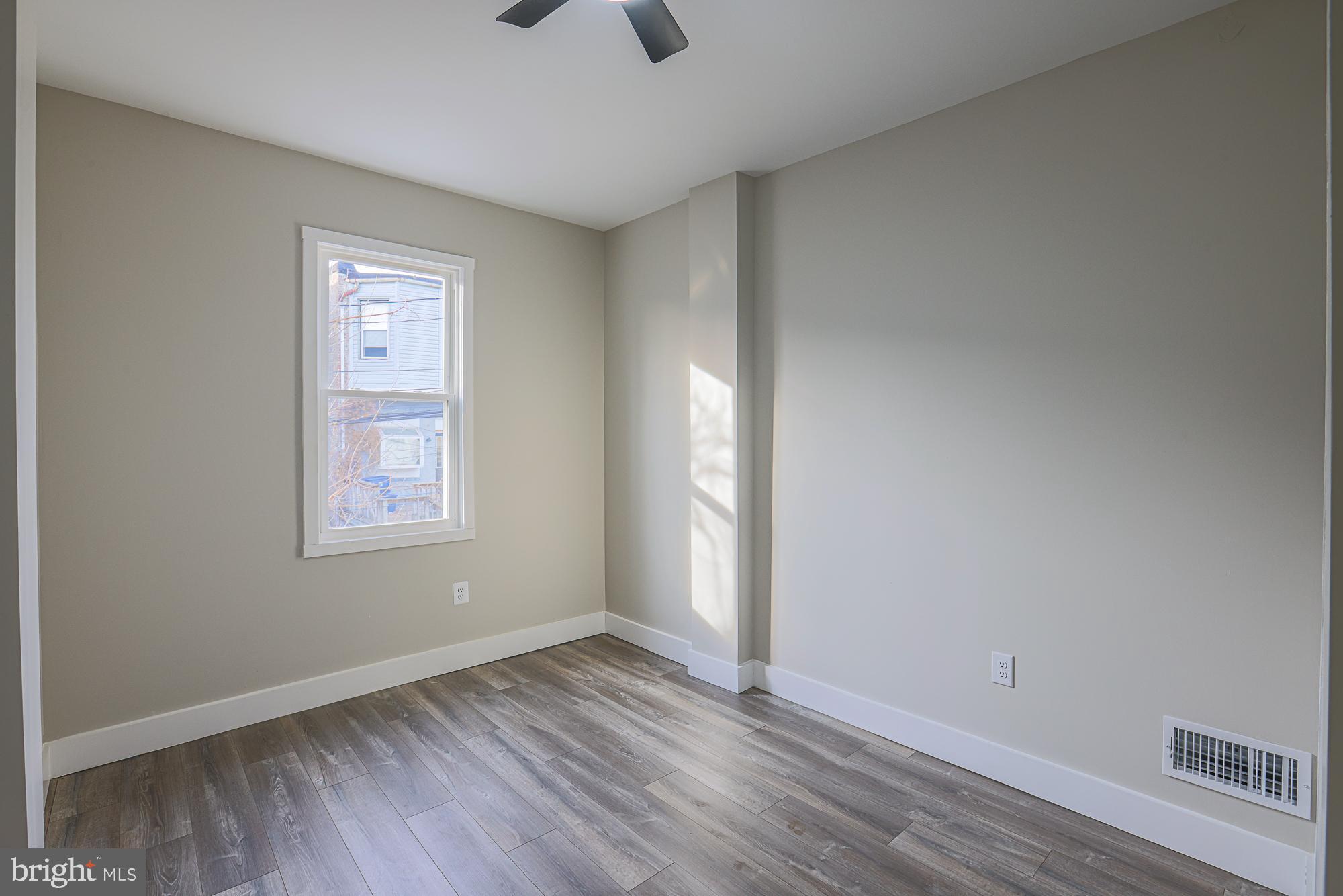 1728 Ruxton Avenue Baltimore, MD 21216 - Photo 26 of 43 an empty room with wooden floor and windows