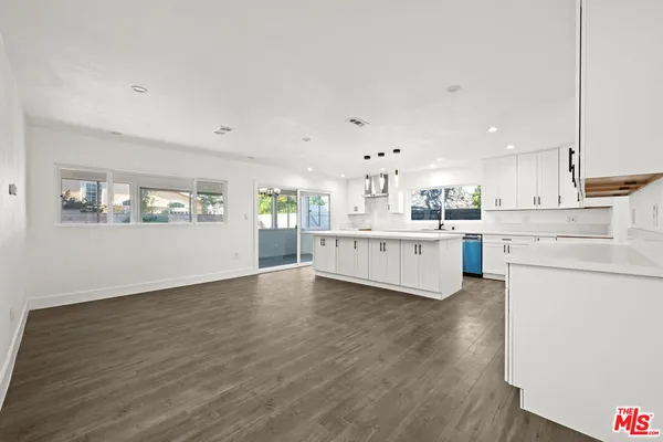 a view of a kitchen with wooden floor and electronic appliances