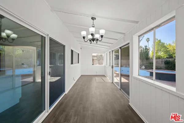 a view of a big room with wooden floor a chandelier