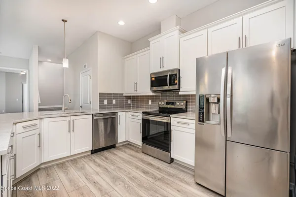 a kitchen with a refrigerator a sink and cabinets