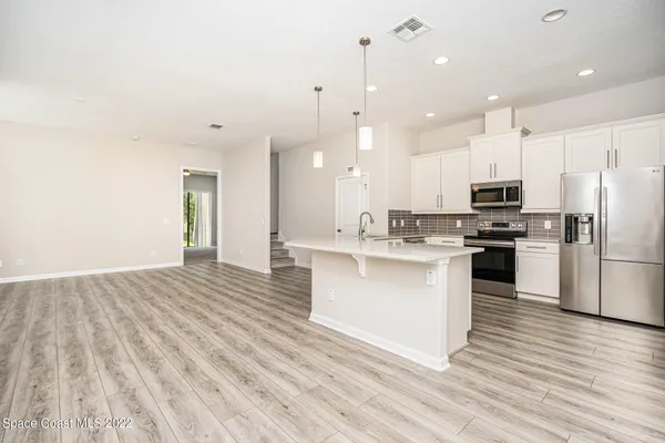a kitchen with stainless steel appliances granite countertop a refrigerator and a stove top oven