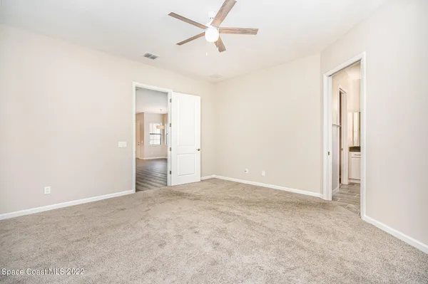 an empty room with closet and windows