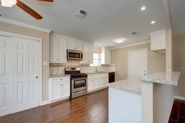 a kitchen with a sink stove top oven and refrigerator